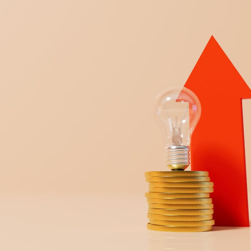 Arrow pointing upwards alongside stack of coins